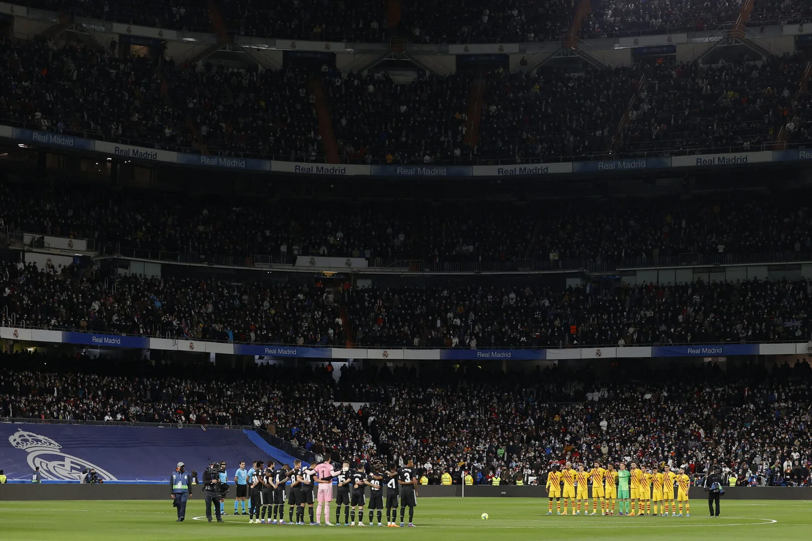Real Madrid and Barcelona players lined up in a packed stadium