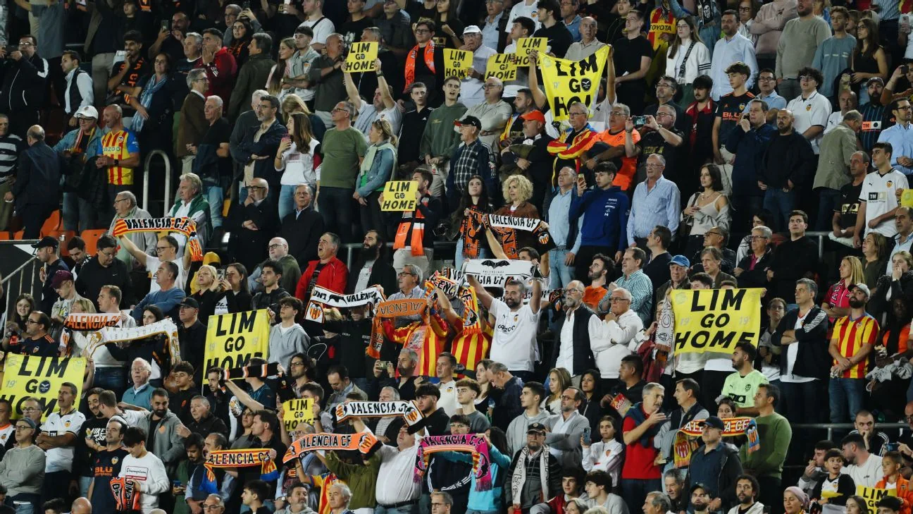 Valencia supporters holding yellow Lim Go Home signs